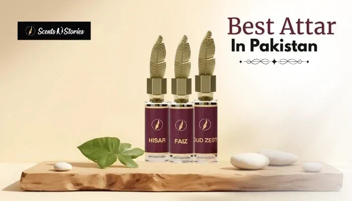 Scents 'N Stories web banner titled "Best Attar In Pakistan" displaying three concentrated attar bottles named Hisar, Faiz, and Oud Zest on a rustic wooden platform.